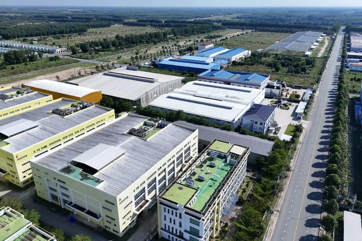 Aerial view of a tree-lined internal road between factory buildings